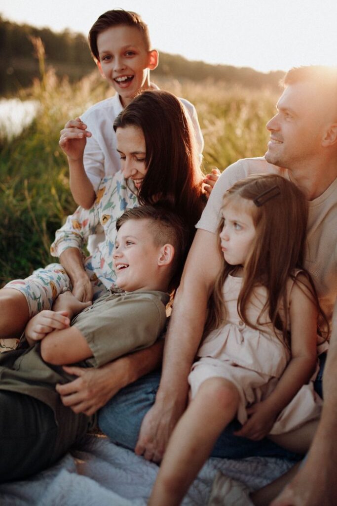 pexels-photo-19510855-19510855 A joyful family enjoying a picnic outdoors with warm sunset vibes.
